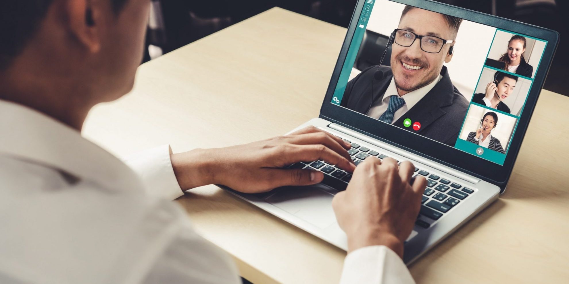 Photo of man in front of laptop illustrates blog "How to Prepare for a Virtual Job Interview"