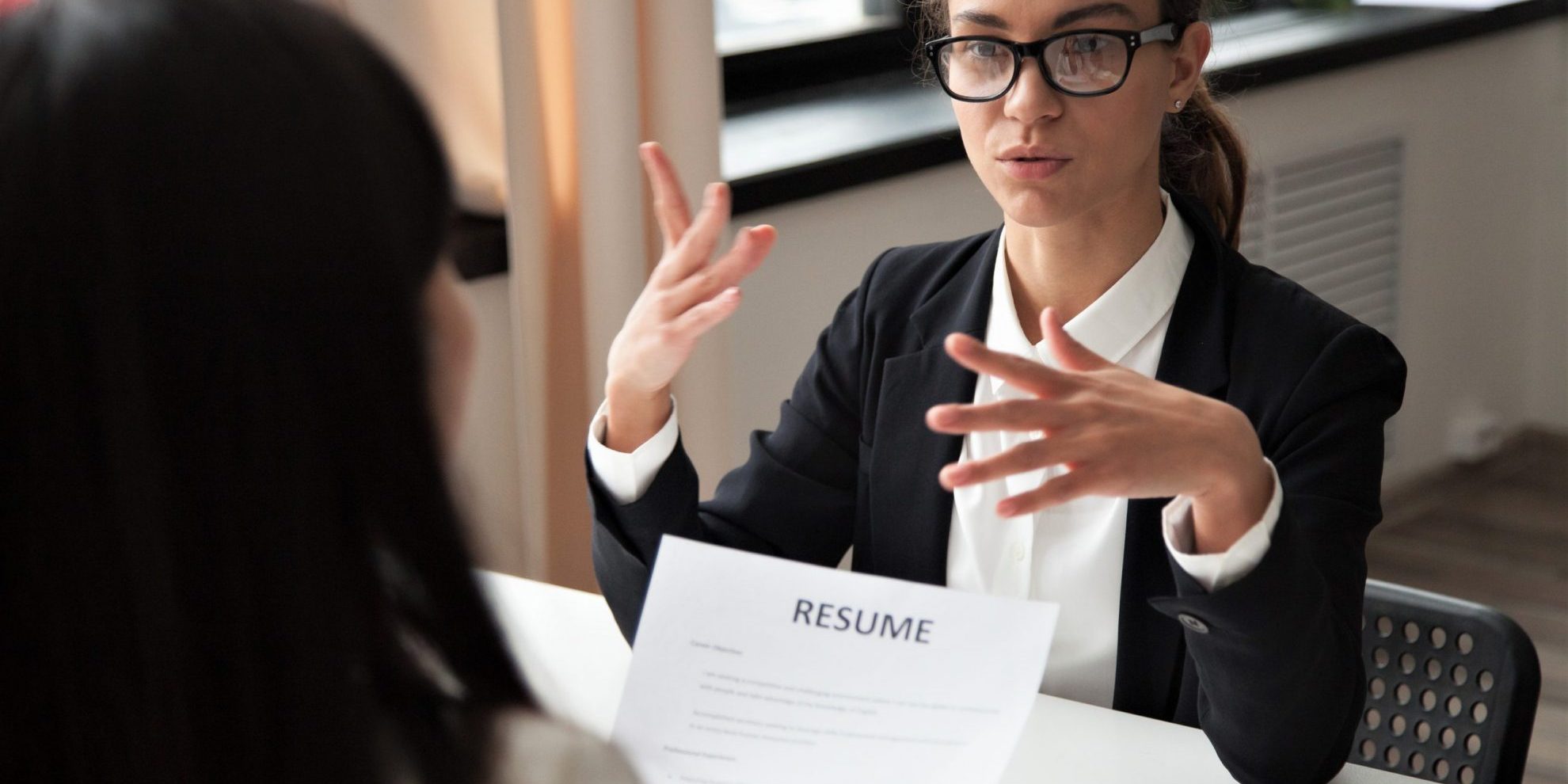 Photo of woman interviewing for a jobillustrates blog: "Job Interviews: What Are Behavioral Interview Questions?"