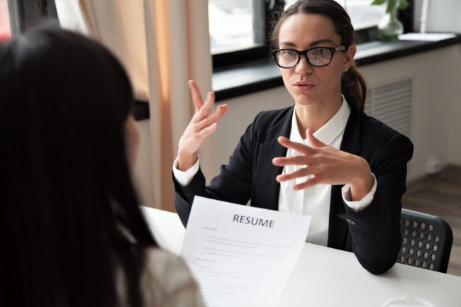 Photo of woman interviewing for a jobillustrates blog: "Job Interviews: What Are Behavioral Interview Questions?"