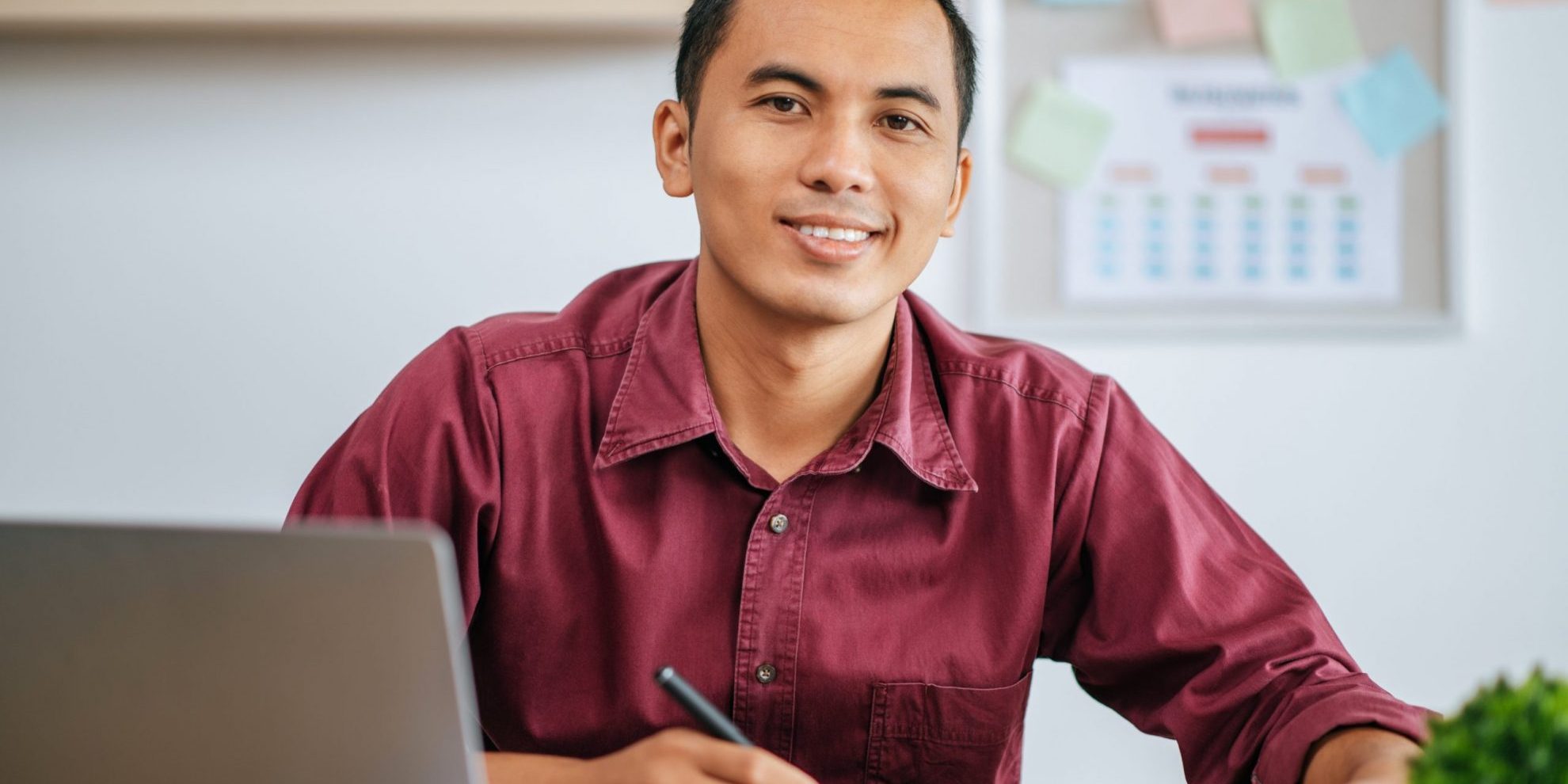 Photo of smiling man sitting at a desk illustrates blog: "Listening Skills"