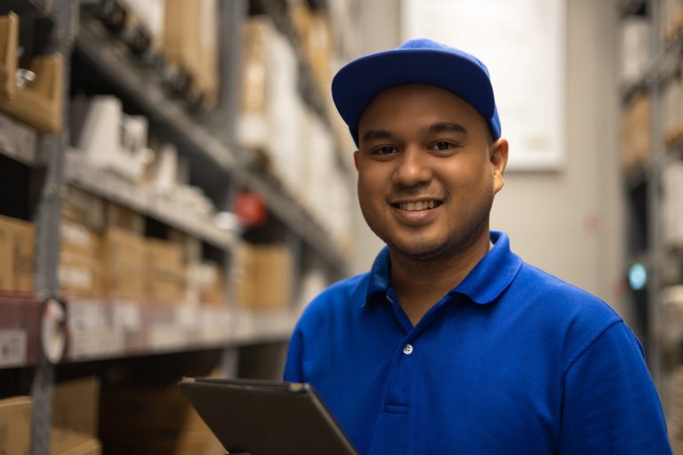 Photo of smiling warehouse worker illustrates blog: "How to Turn a Temporary Job Into a Permanent One"