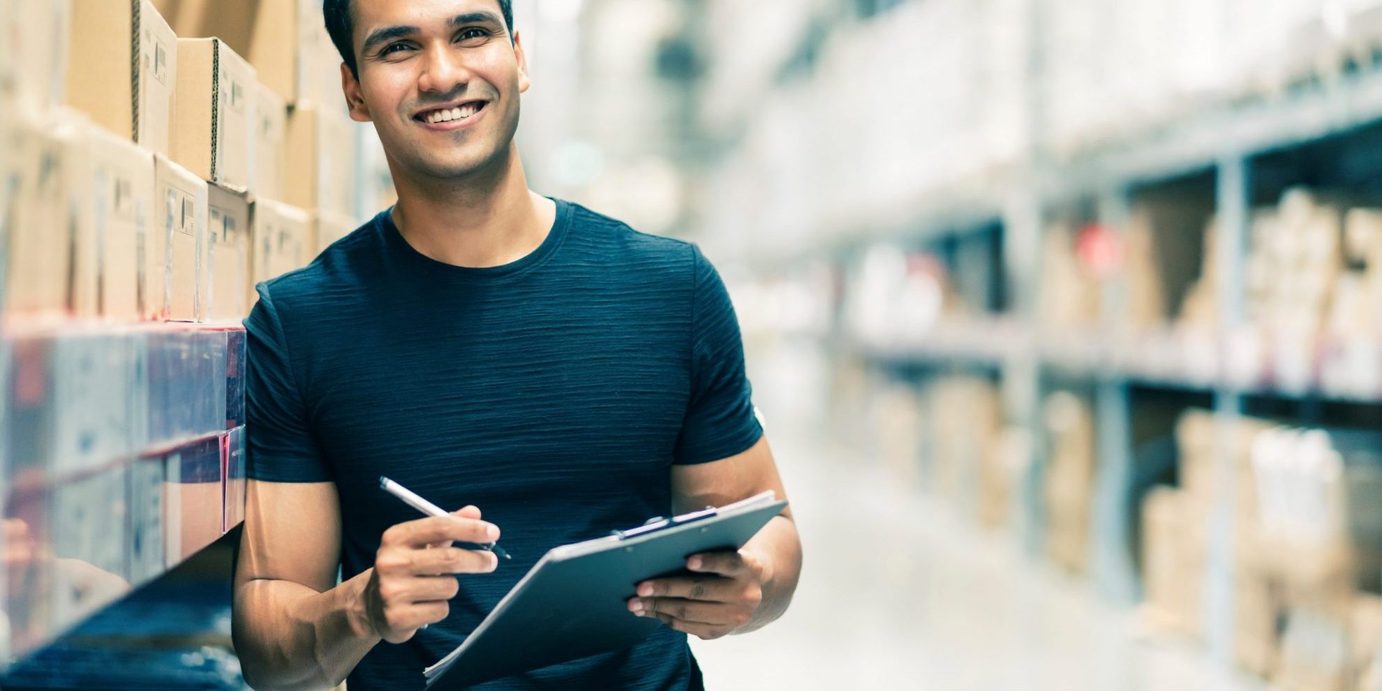 Photo of smiling man with clipboard illustratetes blog: "Cómo convertir tu trabajo temporal en permanente"