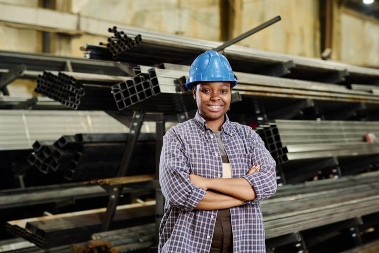 Photo of worker wearing hardhat illustrates blog: "Manufacturing Jobs: Examples and Duties"