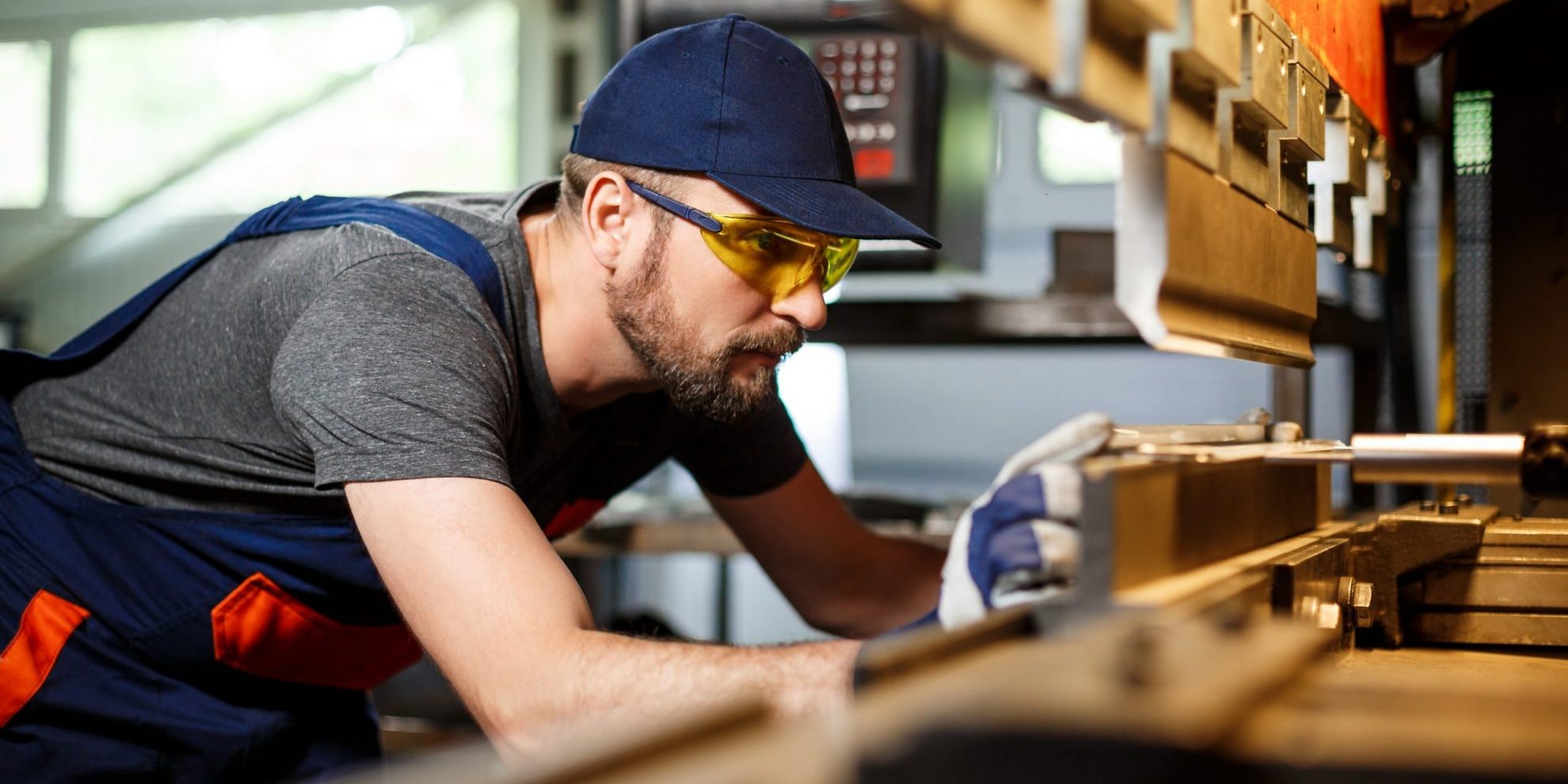 Photo of manufacturing worker with safety glasses and gloves.