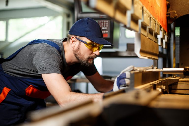Photo of manufacturing worker with safety glasses and gloves.