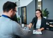 Man and woman shaking hands in office illustrating blog; "How To Prepare for an Office Job Interview? "